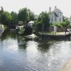 The Soar disappears under the low road bridge towards the weir, with the lock on the right.  The barge is still there, occupied.  The buddleia apparently growing from the side of the barge is actually in a tethered, floating tyre by John Howarth – 30 July 2008